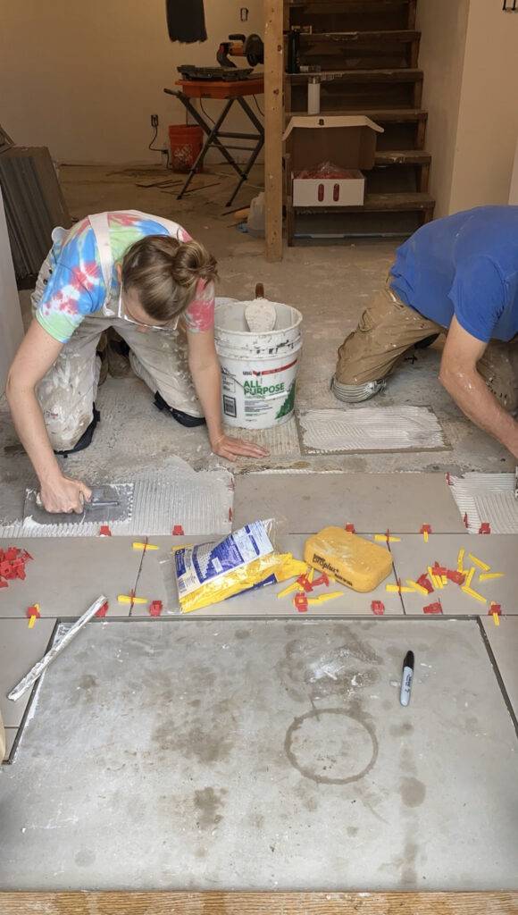 Bea and Hector lay down tiles.